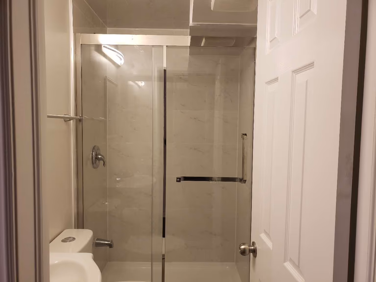 This Markham basement bathroom renovation features a modern glass-enclosed shower with clean tile finishes and updated plumbing fixtures. The space is designed for practicality and durability, incorporating a clear sliding glass door, neutral wall tiles, and efficient lighting to enhance brightness in the basement environment. Compact layout planning ensures comfortable use while maintaining a clean and contemporary look. This professionally completed basement bathroom highlights quality workmanship and thoughtful design, making it a functional addition to a fully finished basement in Markham.