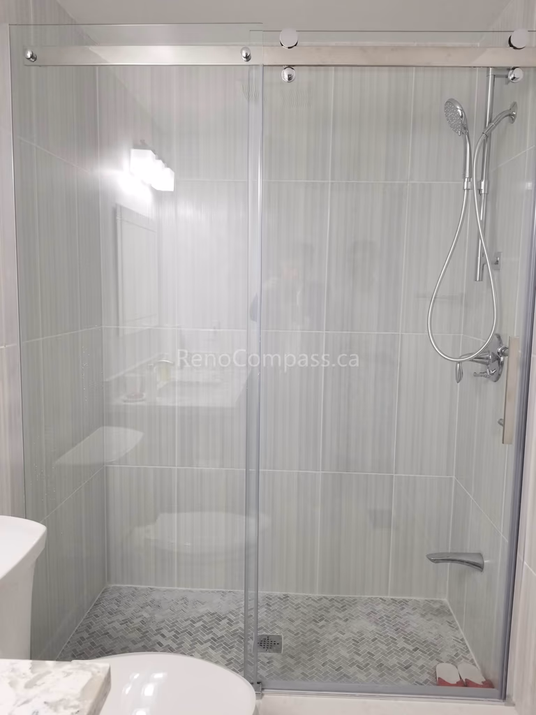 This Mississauga bathroom renovation features a sleek frameless glass shower enclosure with modern vertical wall tiles and mosaic shower flooring. The clean, minimalist design enhances brightness and creates a spacious, contemporary feel while improving everyday functionality and comfort.

Completed by Reno Compass Inc., this bathroom upgrade combines elegant finishes, quality materials, and professional installation to deliver a stylish and durable shower space for modern living.