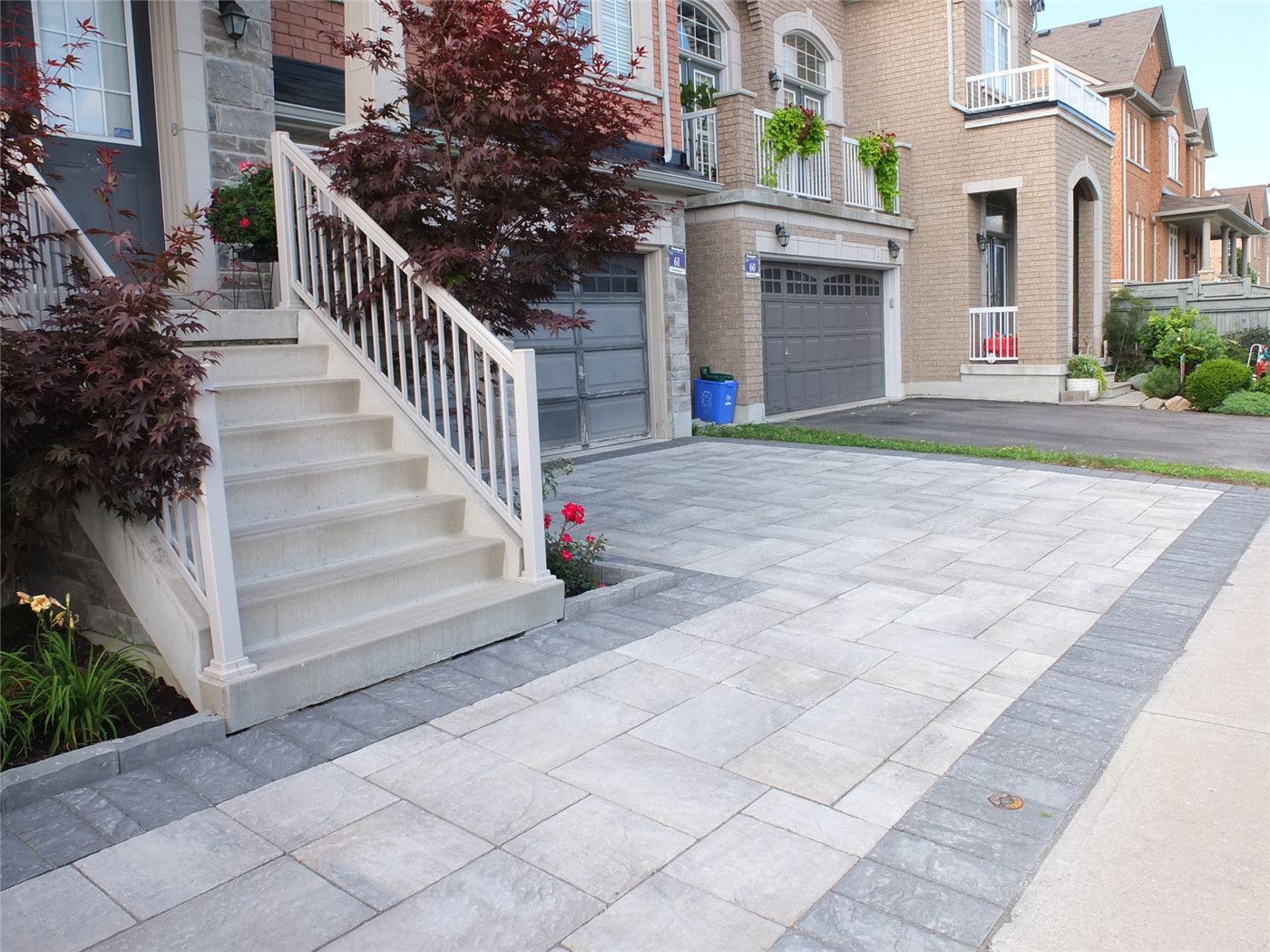 This Toronto landscaping renovation features a professionally designed interlocking driveway and front entrance upgrade that enhances curb appeal and durability. The project includes large-format stone interlocking, clean border detailing, and a modern front stairway with white railings, creating a refined and welcoming exterior. Completed by an experienced Toronto renovation and landscaping team, the design combines functionality, drainage planning, and long-term stability while delivering a clean, elegant residential look perfect for modern homes.