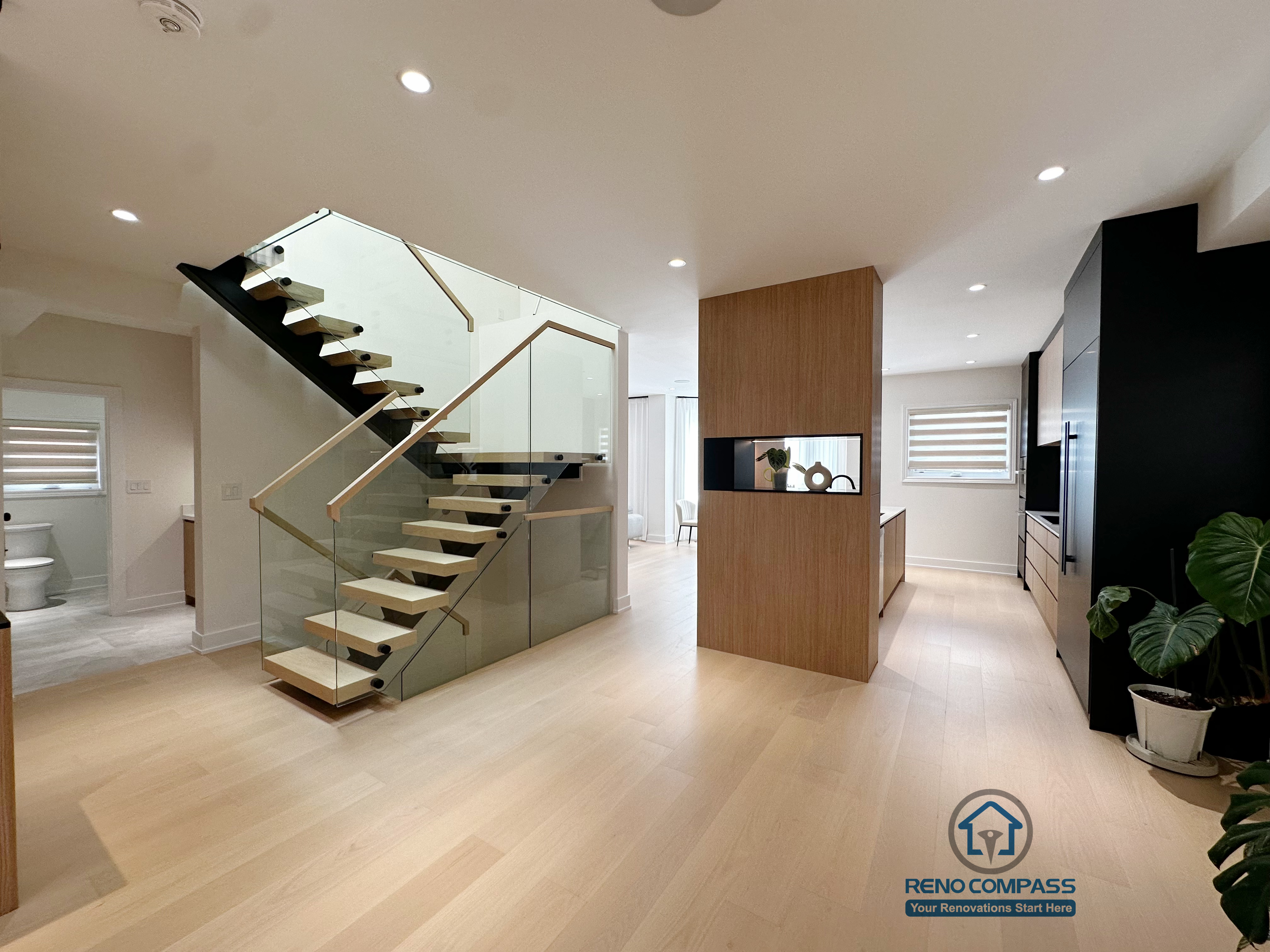 This project integrates a floating steel staircase seamlessly into an open-concept living area. The open stair structure enhances visual flow and spatial connection, while the glass railing and wood treads reduce visual weight. Paired with custom wood finishes and neutral tones, the space feels bright, airy, and well-suited for everyday living.