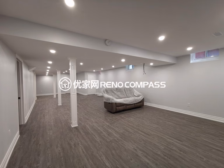 Richmond Hill basement renovation featuring a spacious open-concept layout, modern waterproof flooring, structural support columns, and recessed pot light installation. The newly finished basement offers bright lighting and flexible living space, completed by a professional Toronto renovation company.