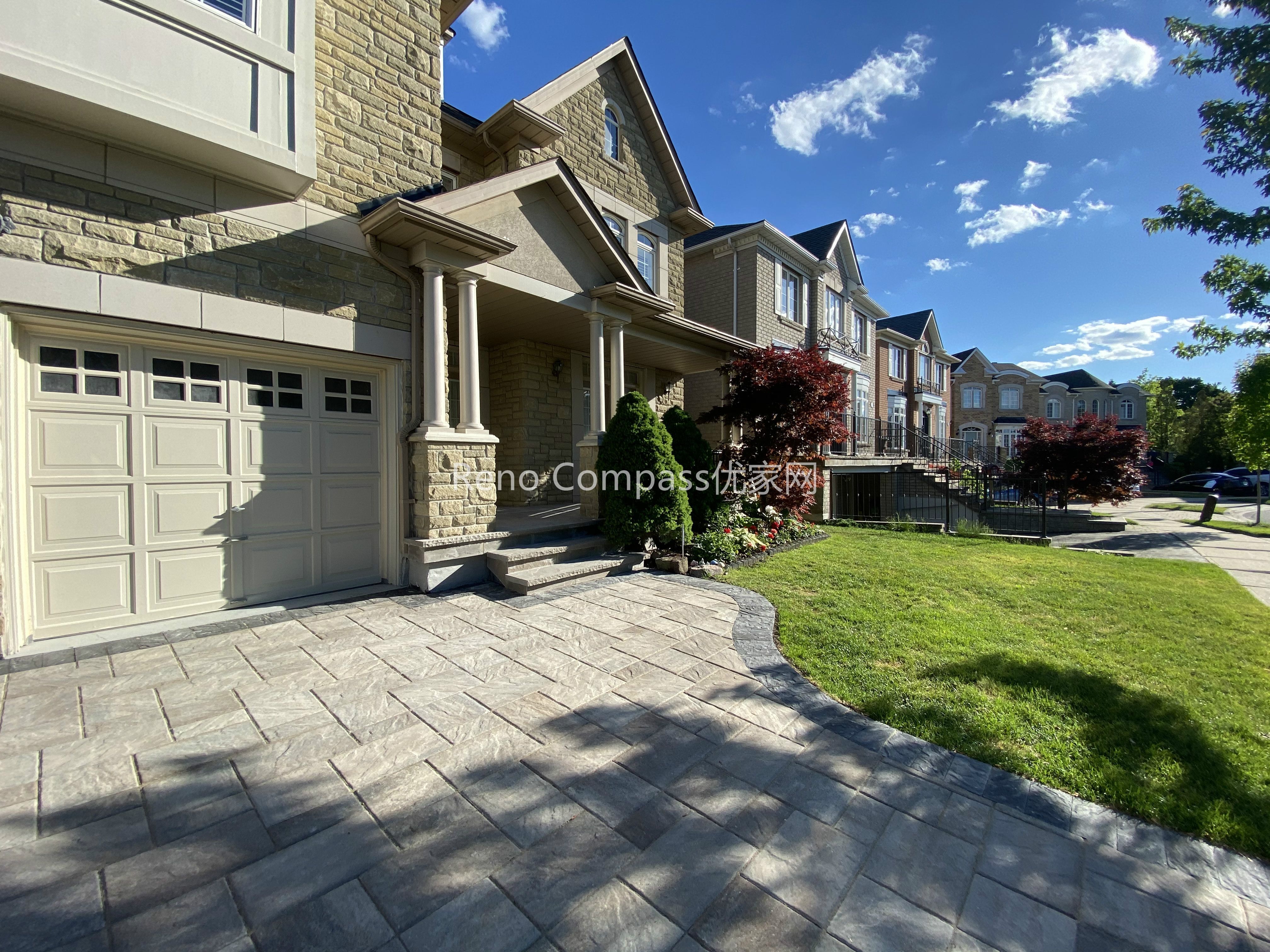 This image showcases a completed driveway interlocking project in North York, featuring natural stone pavers with a structured layout and clean border detailing. The interlocking driveway is designed to provide long-term durability, proper drainage, and a refined curb appeal that complements the home’s stone façade. Precise alignment and material selection ensure a balanced appearance while supporting daily vehicle use. Completed by a Toronto landscaping and interlocking contractor, this North York driveway renovation highlights quality craftsmanship, structural stability, and a practical approach to residential outdoor paving.