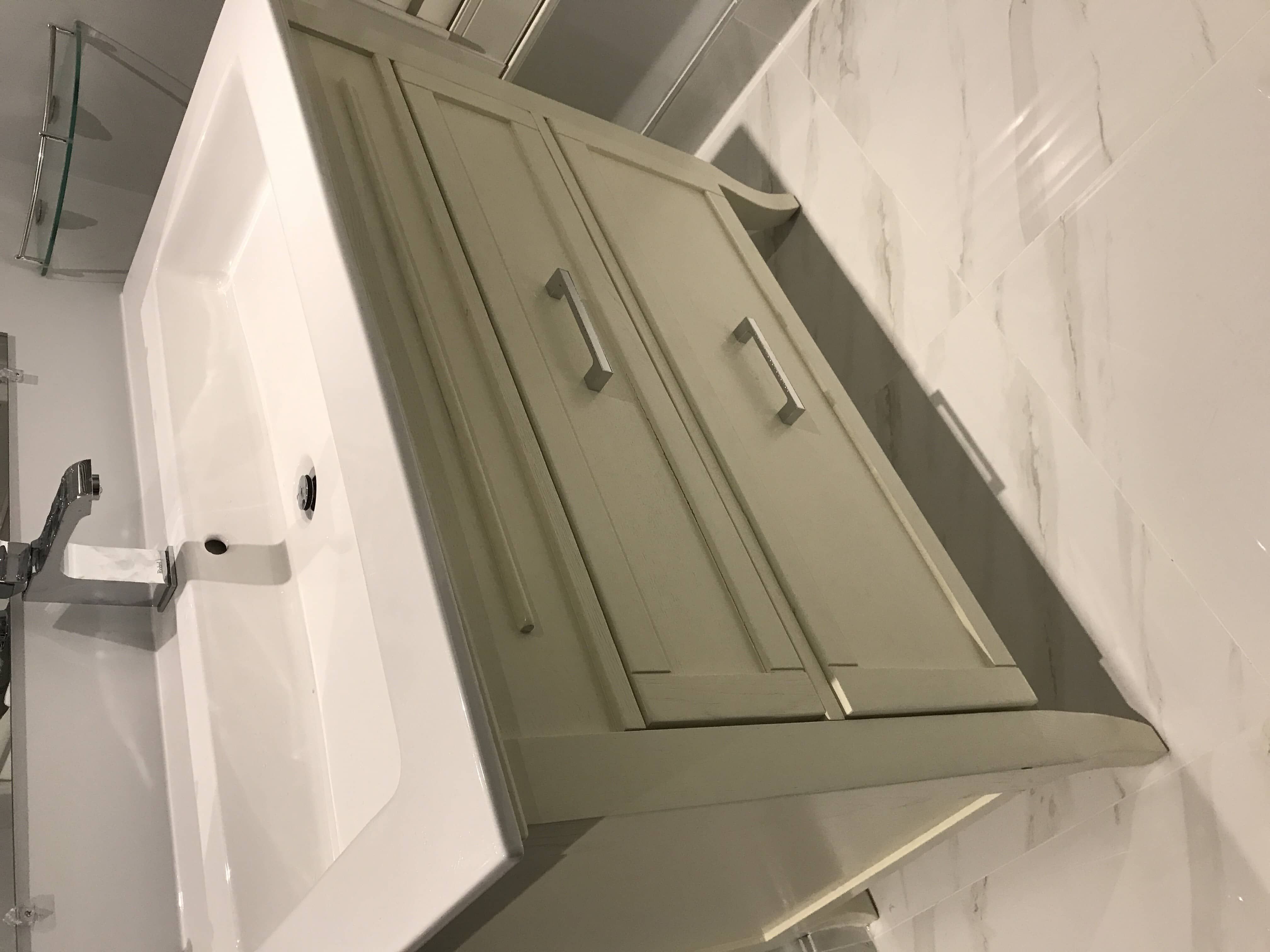 Stylish Toronto bathroom renovation featuring a modern single vanity with soft-close cabinetry, sleek chrome faucet, and white quartz countertop paired with polished wall tiles for a fresh, elegant look.