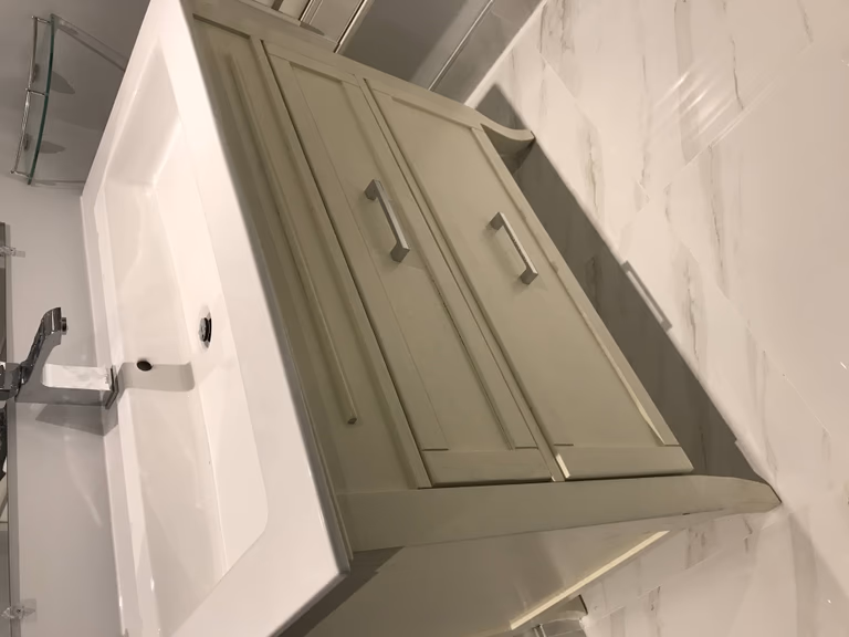 Stylish Toronto bathroom renovation featuring a modern single vanity with soft-close cabinetry, sleek chrome faucet, and white quartz countertop paired with polished wall tiles for a fresh, elegant look.