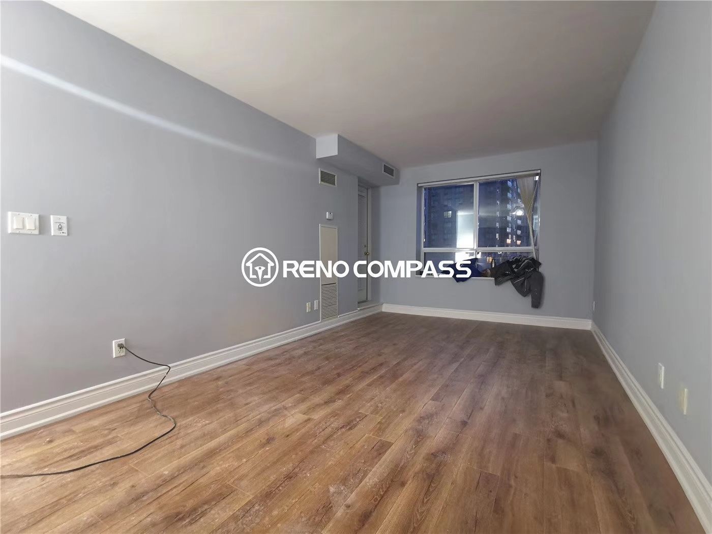 This Richmond Hill condo renovation features a refreshed living room with newly installed wood flooring, updated wall finishes, and improved interior layout. The space was redesigned to create a brighter, more modern, and comfortable living environment suited for urban condominium living. Large windows enhance natural light while the upgraded flooring and clean wall design bring a contemporary feel to the unit. Completed by Reno Compass, a professional Toronto renovation company, this project highlights efficient condo interior renovation solutions that improve both functionality and property value.