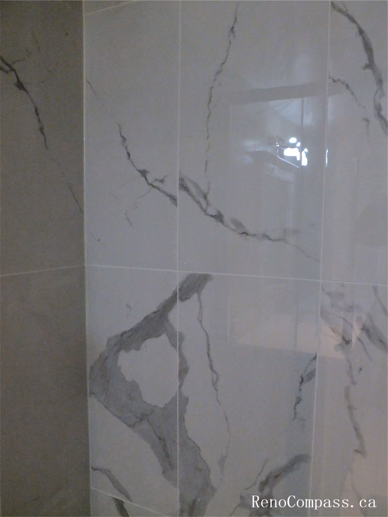 Close-up view of marble-style wall tiles installed in the shower area during this Ajax basement renovation. The large-format tiles with natural grey veining create a clean and elegant bathroom design while providing a durable, moisture-resistant surface ideal for shower spaces. Completed by a professional Toronto Renovation Company, this tile installation enhances both the modern aesthetic and long-term functionality of the basement bathroom.