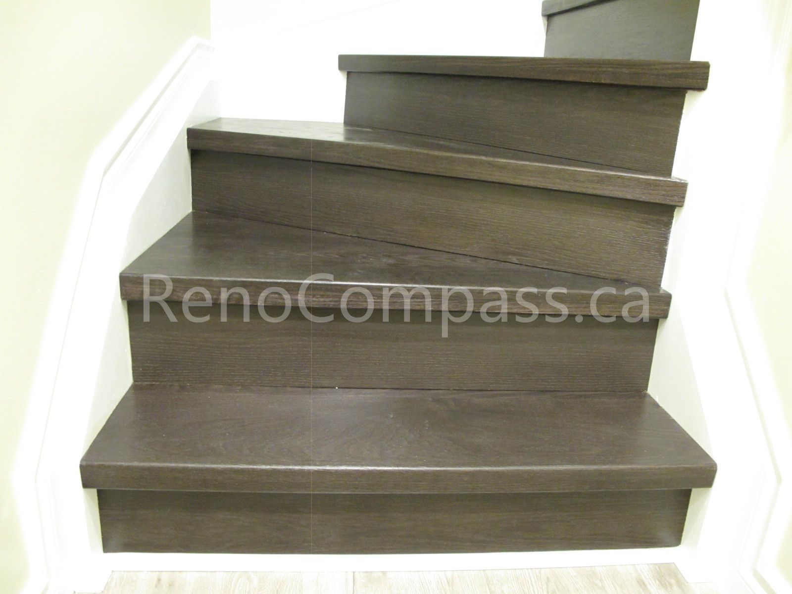 Custom dark wood staircase installed in this Markham basement renovation, featuring durable step finishing and clean white railings for a modern contrast. Completed by Reno Compass, this upgraded stair system enhances safety, durability, and seamless design connection between basement and main floor.