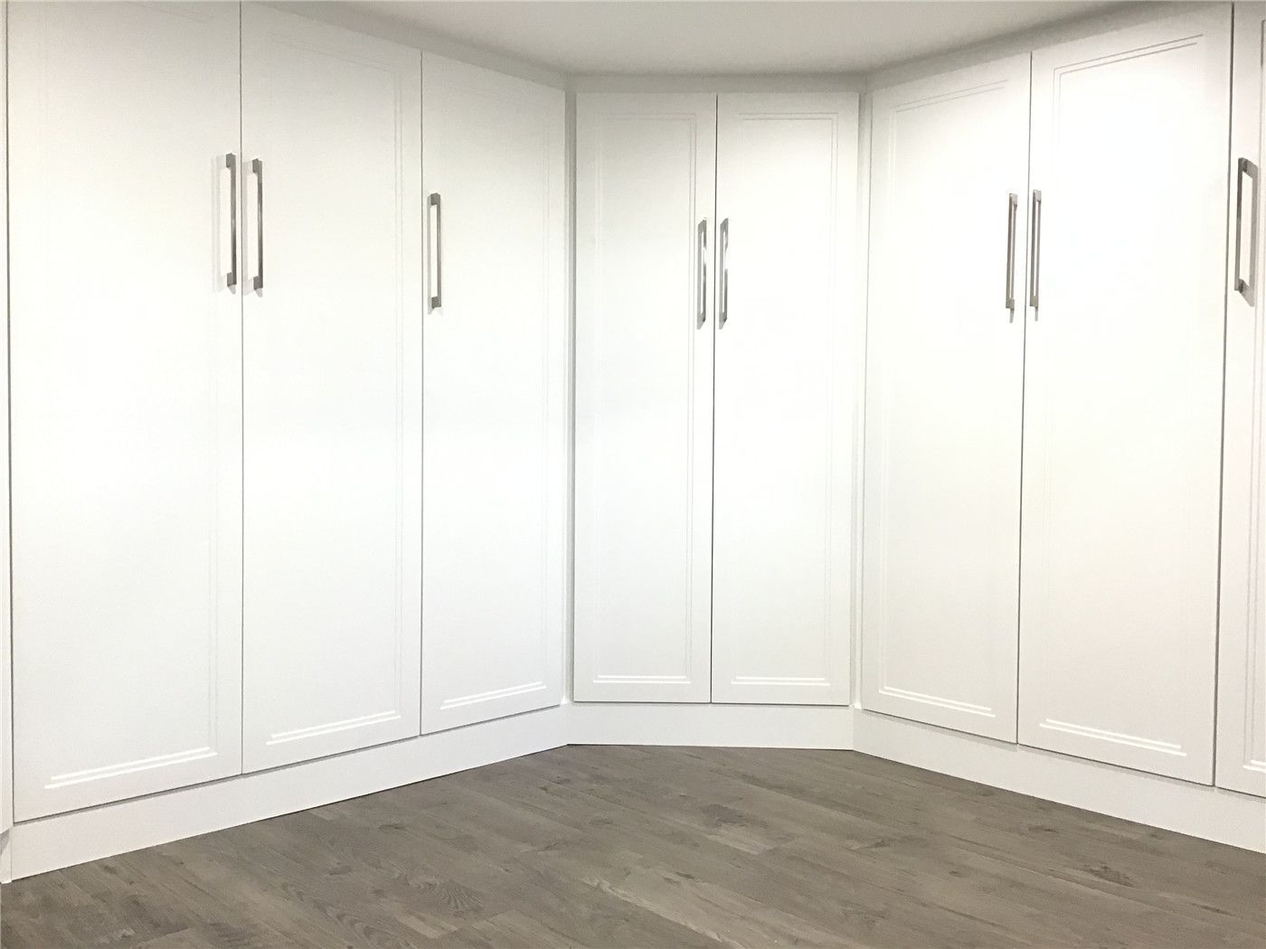 Aurora basement renovation featuring custom-built white storage cabinets designed for maximum organization and clean aesthetics. The floor-to-ceiling cabinetry provides practical storage while maintaining a bright, modern look that complements the vinyl plank flooring. Professionally crafted and installed by a trusted Toronto renovation company to enhance both function and visual appeal.