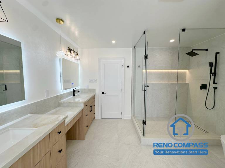 A luxury primary bathroom featuring a frameless glass walk-in shower, custom double vanity, quartz countertops, matte black fixtures, recessed shower niche lighting, and large-format porcelain tiles. Completed as part of a whole home renovation in Markham, Ontario, this spa-inspired bathroom combines modern elegance, functionality, and premium craftsmanship by Reno Compass.