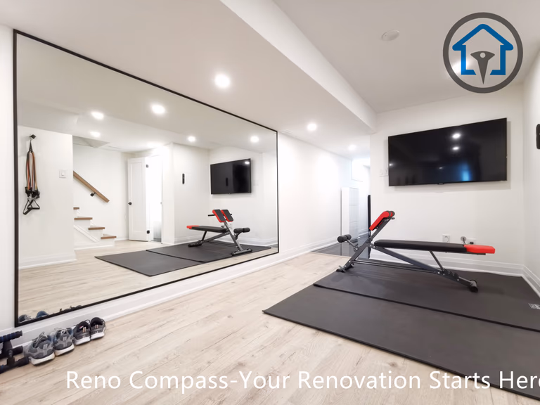 This North York basement renovation transforms the space into a modern home gym featuring a full mirror wall, recessed ceiling lighting, and durable light-tone flooring. The open layout improves brightness and functionality, creating a clean and versatile workout area completed by a Toronto renovation company focused on practical design and high-quality finishing.