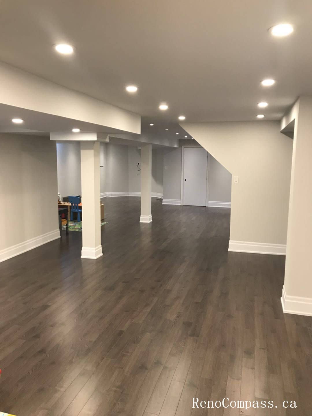 Richmond Hill basement renovation featuring a spacious open-concept layout with new hardwood flooring, recessed LED lighting, and upgraded structural finishing. This professionally finished basement enhances usable living space, comfort, and property value while maintaining a modern, clean interior design suitable for family use and entertainment.