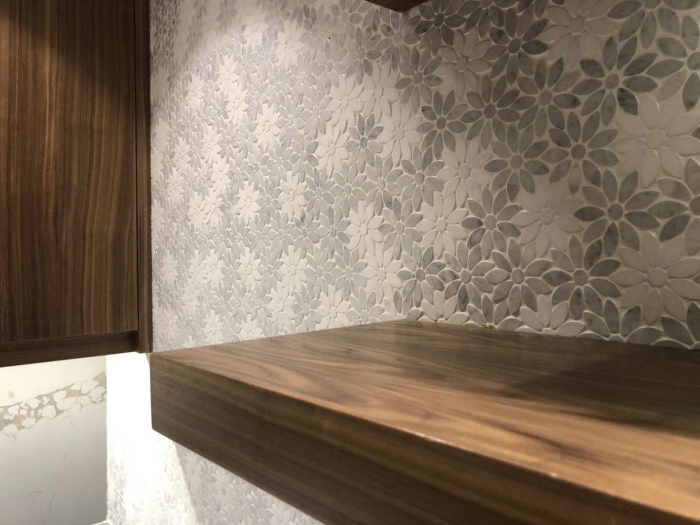 Elegant Markham home renovation featuring a custom floating wood shelf, textured floral feature wall, and warm wood panel detailing. This modern interior upgrade combines functional storage with refined design, creating a cozy and sophisticated living space for contemporary homes in Markham.