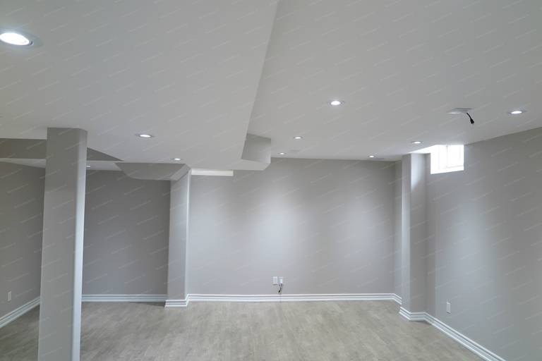 This Richmond Hill basement renovation features recessed ceiling lighting and a high-set window that enhances natural light, improving brightness and overall comfort in the space.