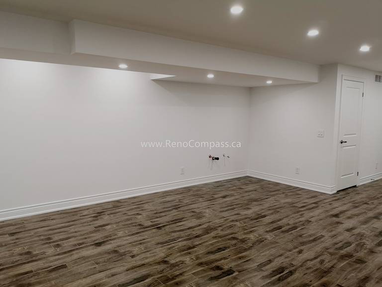 This Vaughan basement renovation project features a spacious open-concept layout with modern recessed lighting, upgraded flooring, and clean white wall finishes. The newly renovated basement offers a bright and functional living space ideal for entertainment, family use, or rental potential. Completed by Reno Compass Inc., this project highlights high-quality craftsmanship and efficient space planning, transforming an unfinished basement into a comfortable and modern extension of the home.