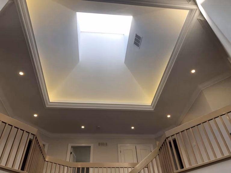This image highlights an open ceiling design with a central skylight, completed as part of a Richmond Hill interior renovation. The elevated ceiling structure enhances natural light penetration, while recessed lighting and clean trim details create a bright and elegant atmosphere. The surrounding upper-level railings add depth and architectural interest, showcasing the design expertise and construction quality of a professional Toronto renovation company.