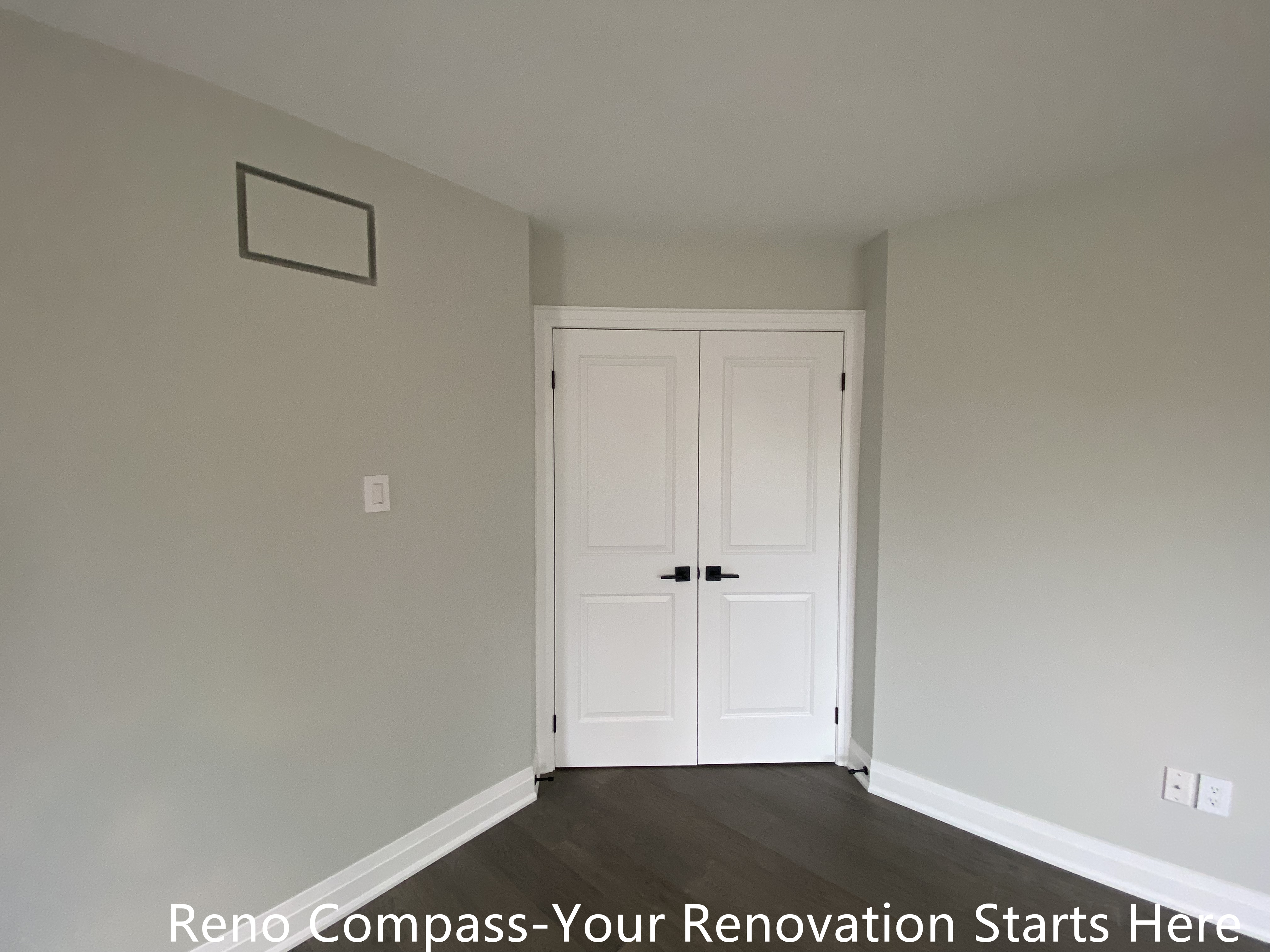 Finished interior room featured in an Oakville interior renovation, highlighting clean wall finishes, modern dark-tone flooring, and classic white double doors. This space reflects precise workmanship, neutral color selection, and functional design completed by a professional Toronto renovation company.