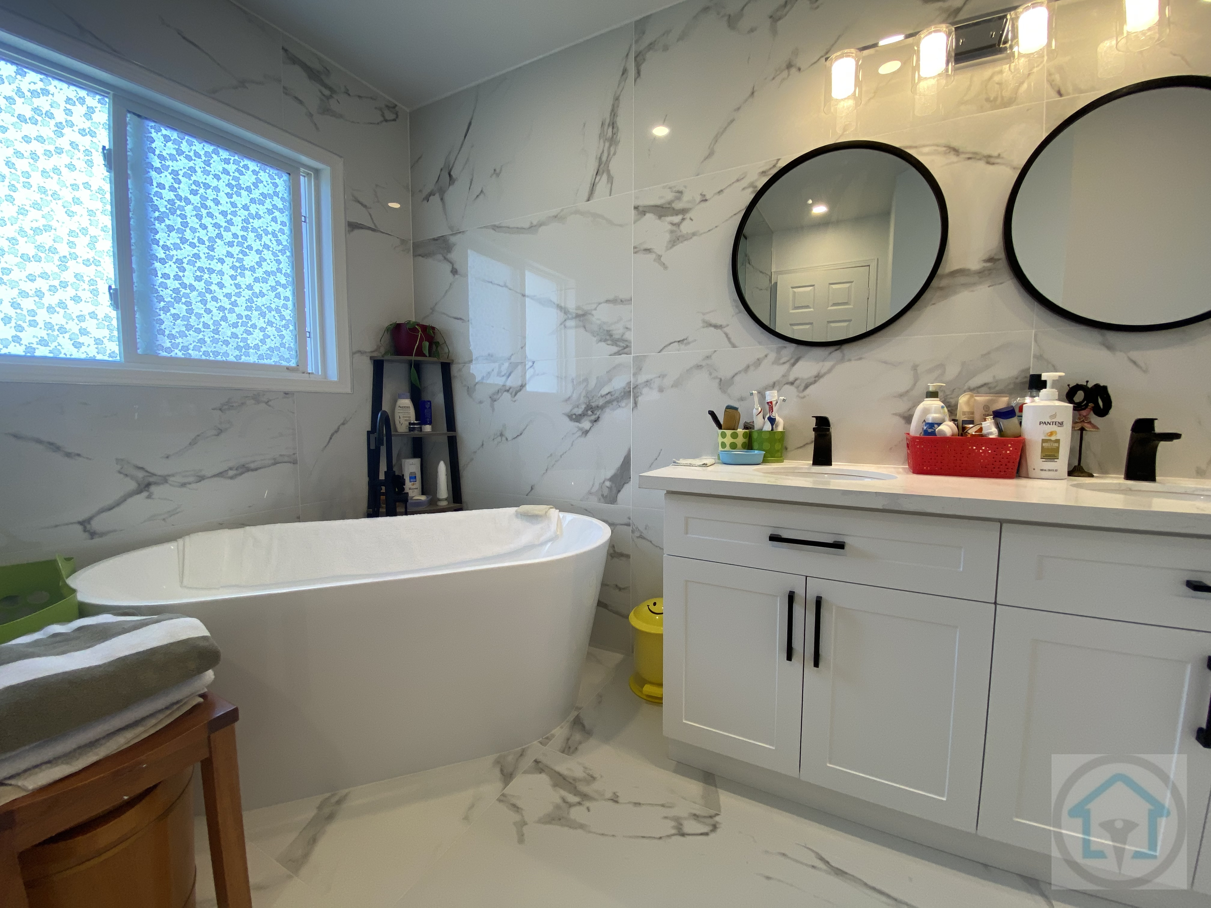 This Richmond Hill bathroom renovation features a modern glass-enclosed walk-in shower paired with a freestanding soaking tub. Large-format marble-look tiles on the walls and floors create a clean, spa-inspired atmosphere, while black fixtures add contrast and visual depth. Designed and completed by Reno Compass Inc., this bathroom balances luxury, comfort, and daily practicality for homeowners in Richmond Hill.