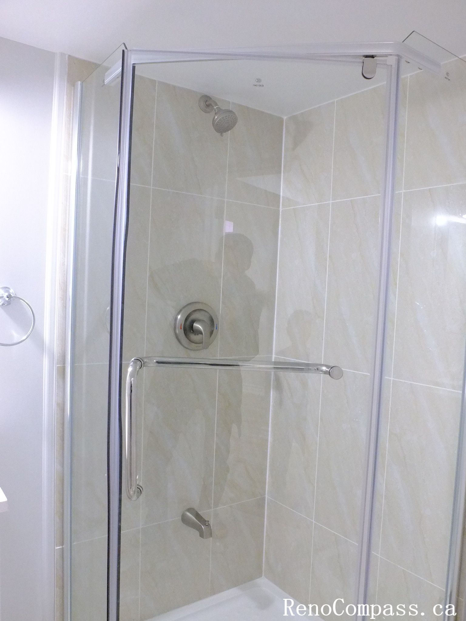 Modern glass shower installation with white tiles and chrome fixtures, part of a sleek Richmond Hill basement bathroom renovation by RenoCompass.ca.
