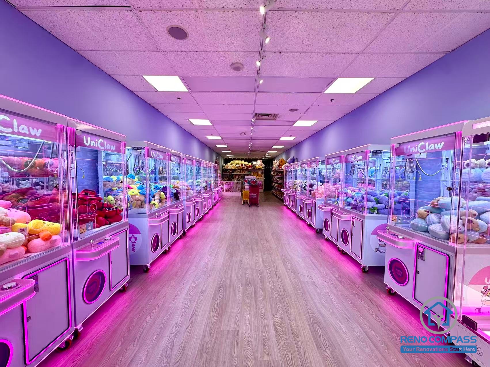 Interior view of an arcade claw machine store at Oakville Place Mall. Machines are arranged on both sides of a central walkway, creating an organized arcade gaming environment similar to a compact indoor playground.
