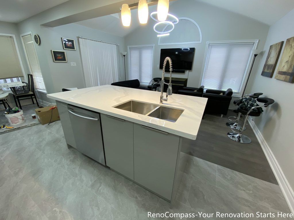 This Mississauga interior renovation features a modern open-concept kitchen with a spacious quartz island, double undermount sink, and sleek contemporary cabinetry. The upgraded layout seamlessly connects the kitchen to the living and dining areas, creating a bright and functional space ideal for everyday living and entertaining. Pendant lighting, durable flooring, and stainless steel appliances enhance both style and practicality. Completed by a trusted Toronto renovation company, this kitchen renovation improves workflow, storage, and overall home value while delivering a clean modern design.