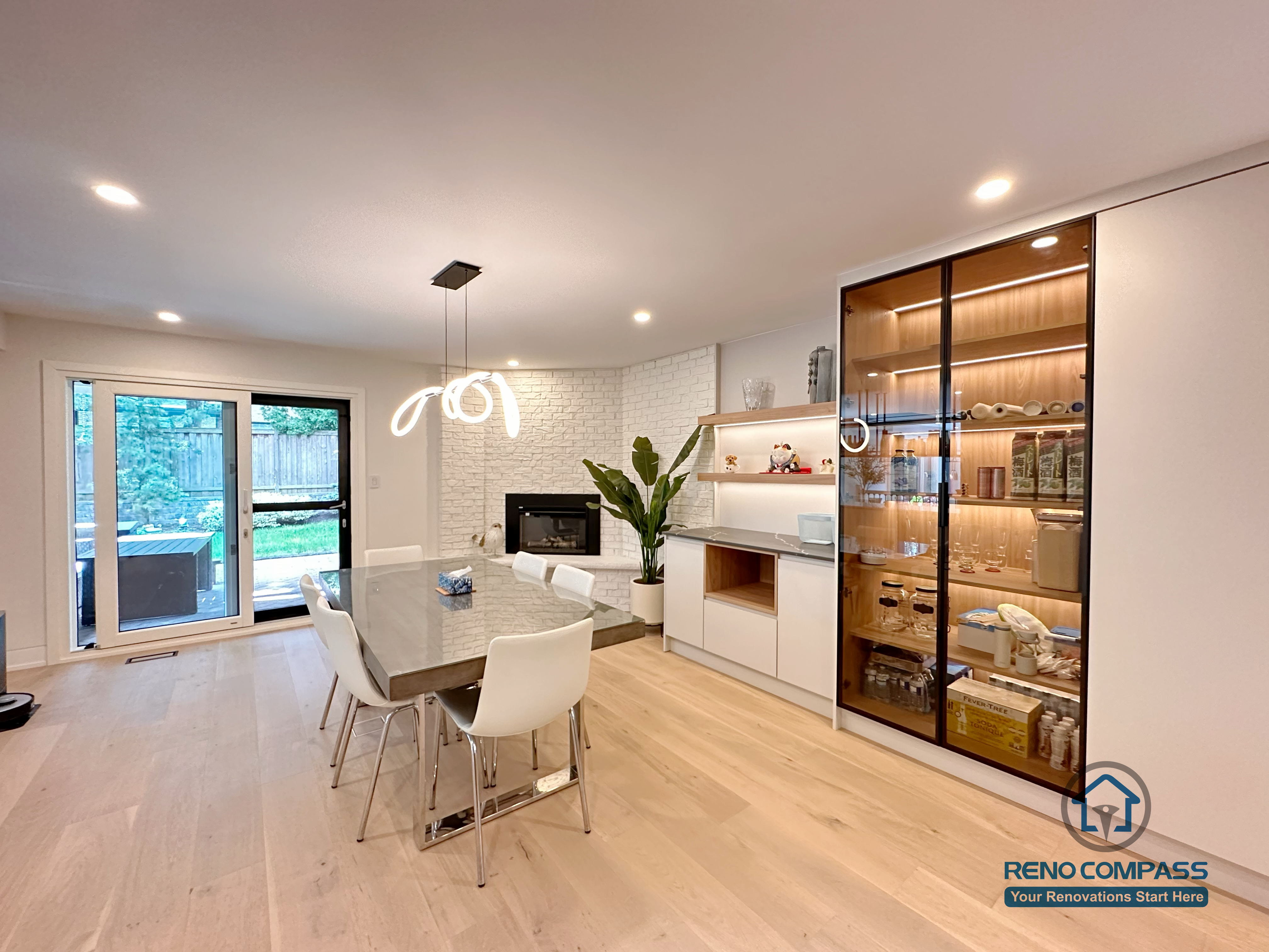 An open-concept dining and living area renovation in Toronto featuring custom cabinetry, built-in glass display storage, and seamless lighting design. This whole-house custom cabinet project enhances space flow and functionality while maintaining a clean, modern aesthetic, completed by a professional Toronto renovation company.