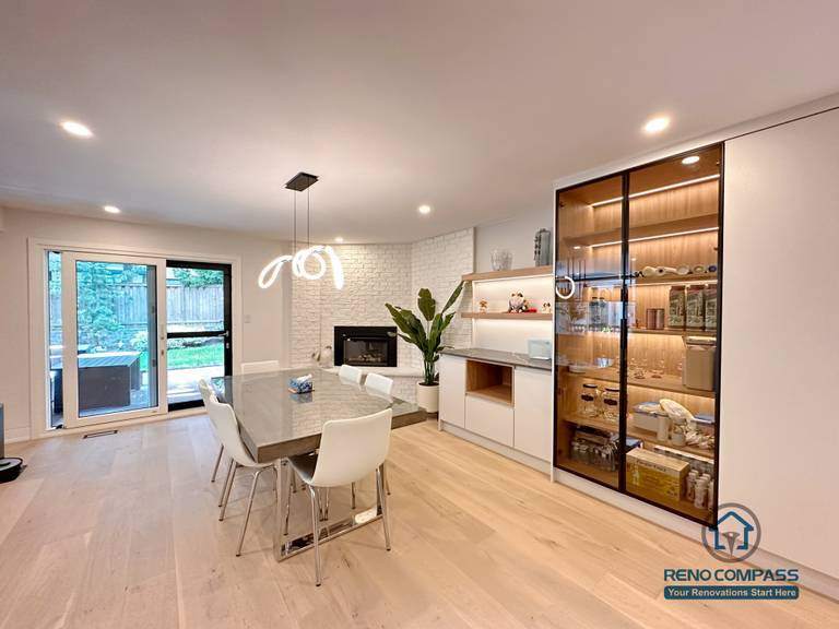 An open-concept dining and living area renovation in Toronto featuring custom cabinetry, built-in glass display storage, and seamless lighting design. This whole-house custom cabinet project enhances space flow and functionality while maintaining a clean, modern aesthetic, completed by a professional Toronto renovation company.