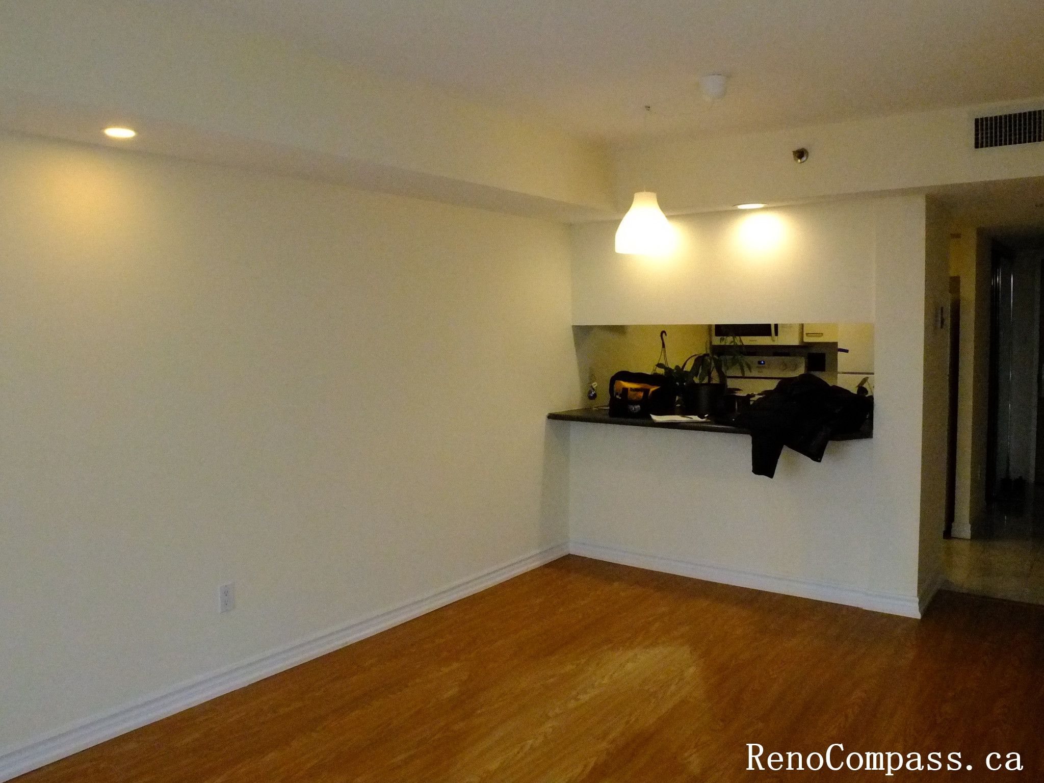 Modern interior renovation in Toronto featuring upgraded flooring and an open-concept living room connected to the kitchen area. The project focuses on improving space flow, lighting, and overall functionality, creating a clean and comfortable residential living environment.