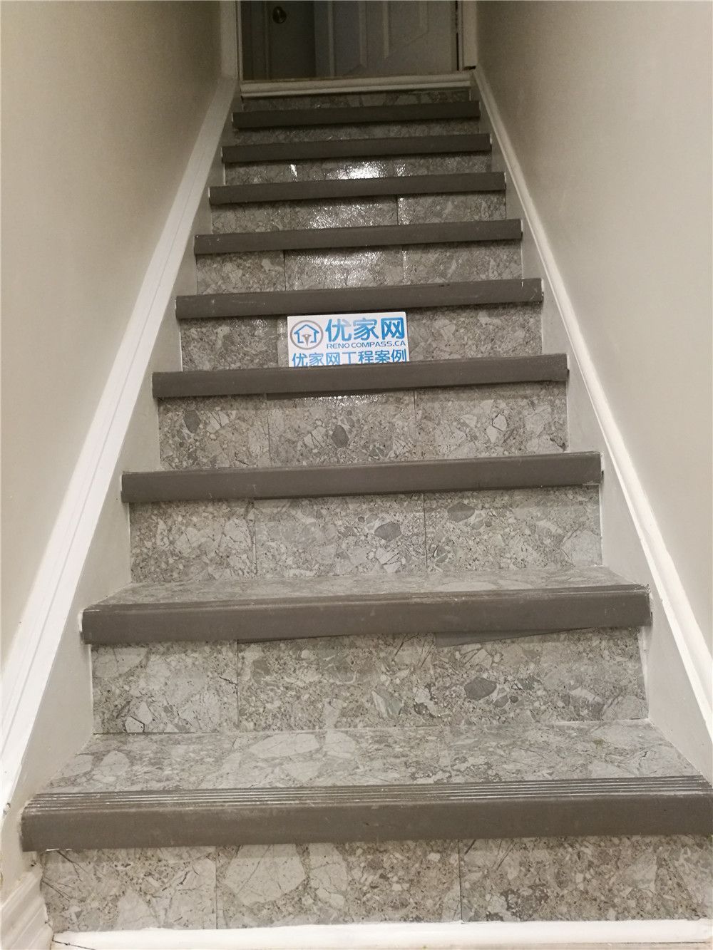 This image features a newly renovated basement staircase in Markham, showcasing upgraded stone-finish stair surfaces paired with durable modern stair nosing. The combination of textured stone-style treads and neutral-toned risers enhances both safety and visual appeal, creating a clean and contemporary transition between floors. Designed for long-term durability and easy maintenance, the staircase complements the overall basement renovation while improving everyday functionality. Completed by a professional Toronto Renovation Company, this stair upgrade highlights quality material selection, precise installation, and modern interior finishing details.