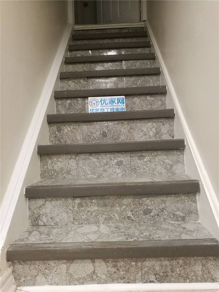 This image features a newly renovated basement staircase in Markham, showcasing upgraded stone-finish stair surfaces paired with durable modern stair nosing. The combination of textured stone-style treads and neutral-toned risers enhances both safety and visual appeal, creating a clean and contemporary transition between floors. Designed for long-term durability and easy maintenance, the staircase complements the overall basement renovation while improving everyday functionality. Completed by a professional Toronto Renovation Company, this stair upgrade highlights quality material selection, precise installation, and modern interior finishing details.
