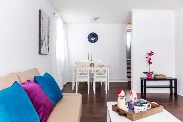 This Toronto interior renovation features a bright open-concept living and dining area with modern flooring, clean white walls, and minimalist furniture. The layout creates a seamless transition between the living room and dining space, maximizing natural light and improving functionality. The renovation highlights a simple yet elegant interior design ideal for comfortable modern living in Toronto homes.