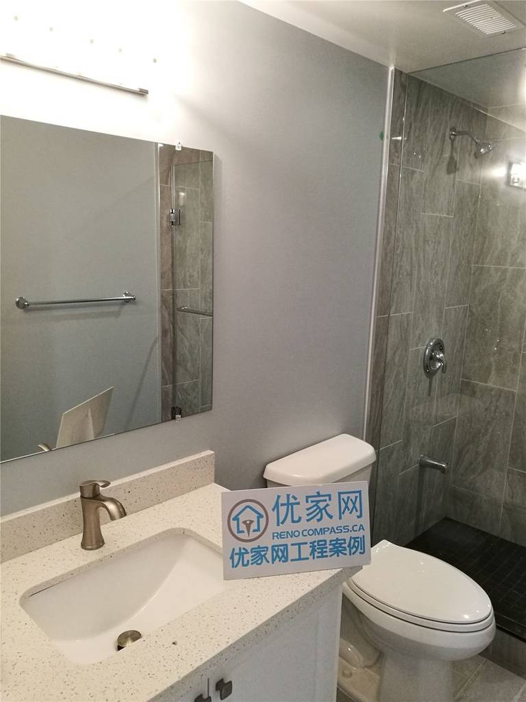 This image showcases a modern basement bathroom completed as part of a North York interior renovation. The space features a glass-enclosed shower, large-format tile finishes, a contemporary vanity, and clean plumbing fixtures. Neutral tones and durable materials enhance both functionality and visual appeal, creating a practical and comfortable bathroom design. This renovation reflects the quality workmanship of a professional Toronto renovation company serving the North York area.