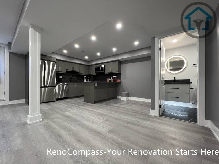 This Vaughan basement renovation features a wide open-concept layout with clear circulation, structural support columns, recessed ceiling lighting, and durable wood-look flooring. The design connects the kitchen area with flexible living and activity zones while maintaining strong structural organization and visual balance. Completed by a Toronto renovation company, this basement renovation highlights efficient space planning and modern finishes suited for multi-purpose lower-level living.