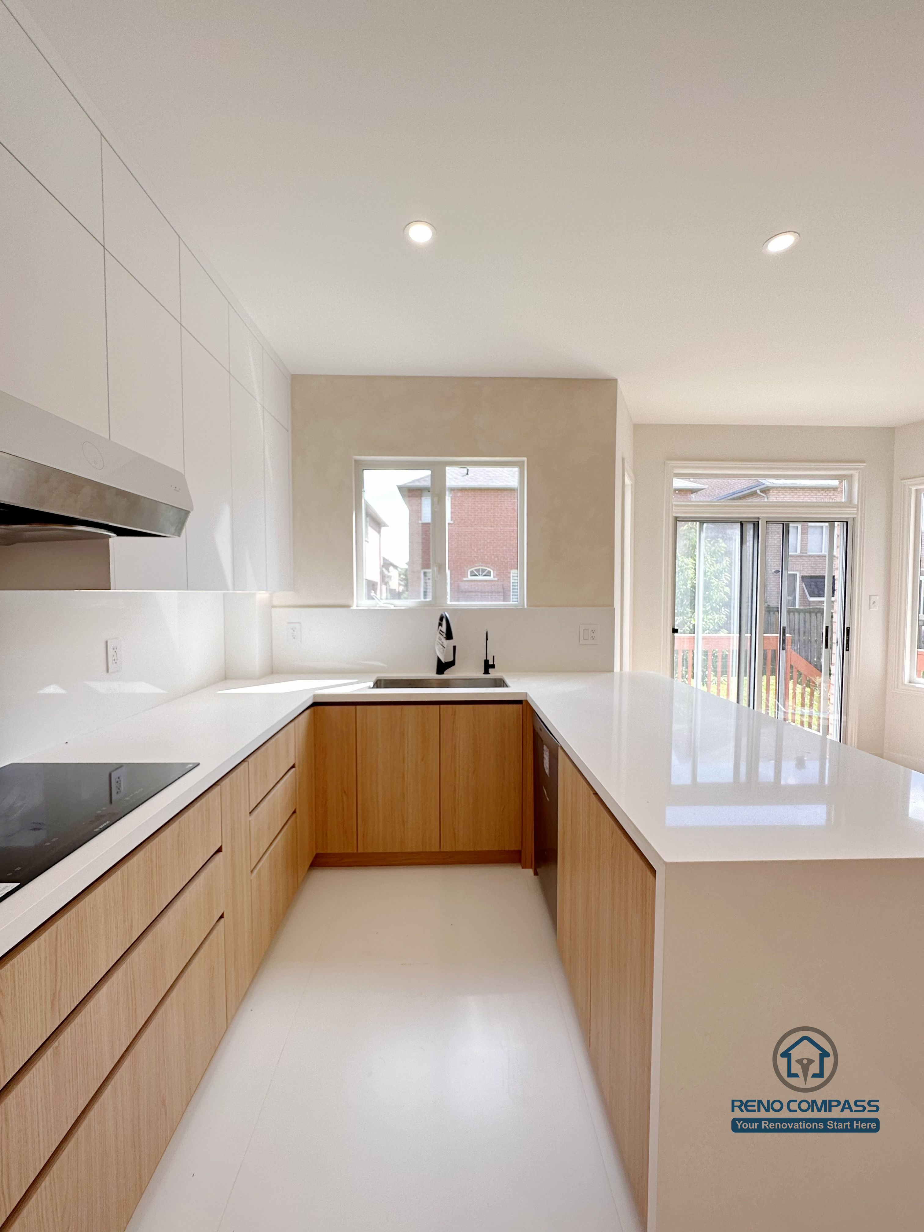 U-shaped kitchen renovation in Markham featuring custom cabinetry, quartz countertops, and a functional island extension. The layout improves workflow efficiency, maximizes counter space, and enhances natural light for a clean, modern kitchen environment.