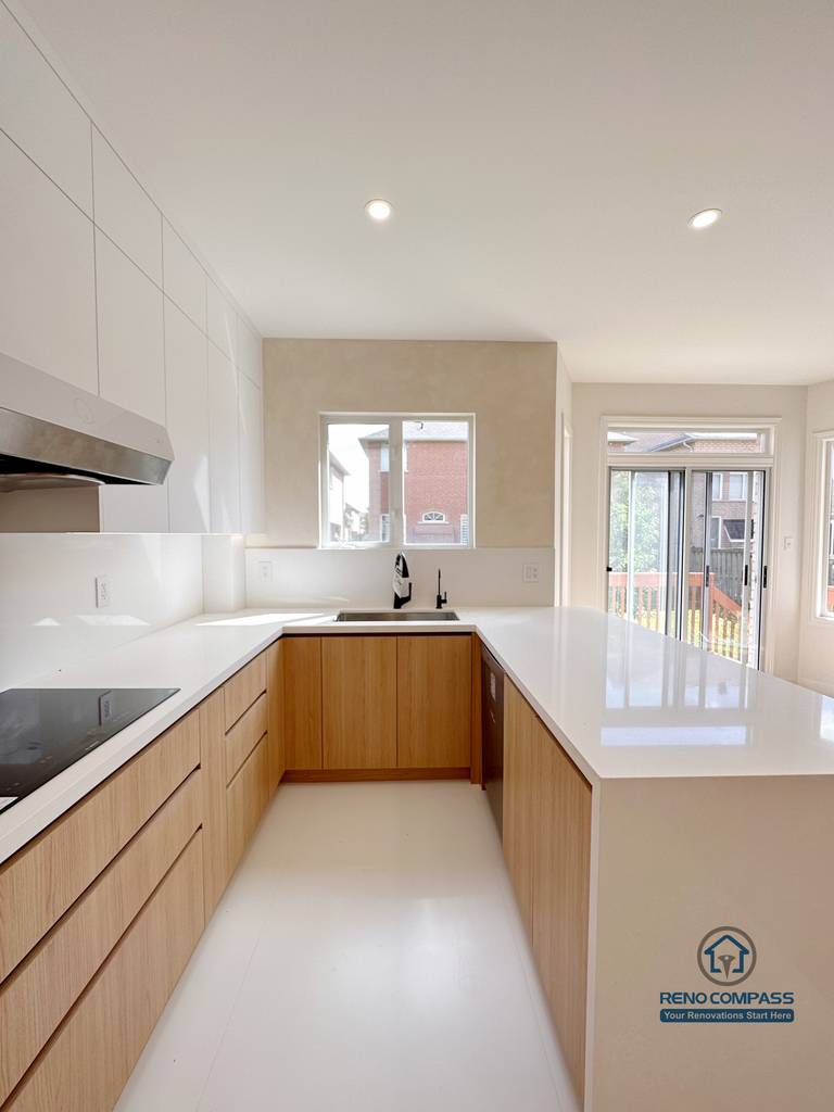 U-shaped kitchen renovation in Markham featuring custom cabinetry, quartz countertops, and a functional island extension. The layout improves workflow efficiency, maximizes counter space, and enhances natural light for a clean, modern kitchen environment.