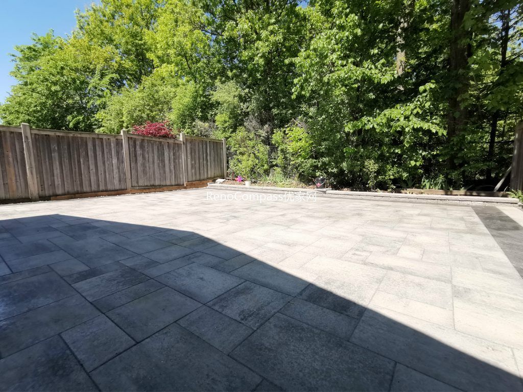 This Mississauga backyard renovation showcases a professionally installed interlocking stone patio with clean modern lines and a raised garden retaining wall. Large-format pavers create a durable and elegant outdoor flooring solution, while the stone border and planting area add depth and structure to the landscape. Completed by an experienced Toronto renovation and landscaping team, this project enhances outdoor usability, drainage, and long-term property value with low-maintenance, high-quality materials.