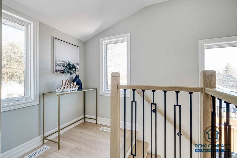 This Georgian interior renovation highlights a bright stair landing with clean railing details, light wood flooring, and natural light from multiple windows. Subtle finishes and balanced proportions reflect the craftsmanship of a Toronto renovation company.