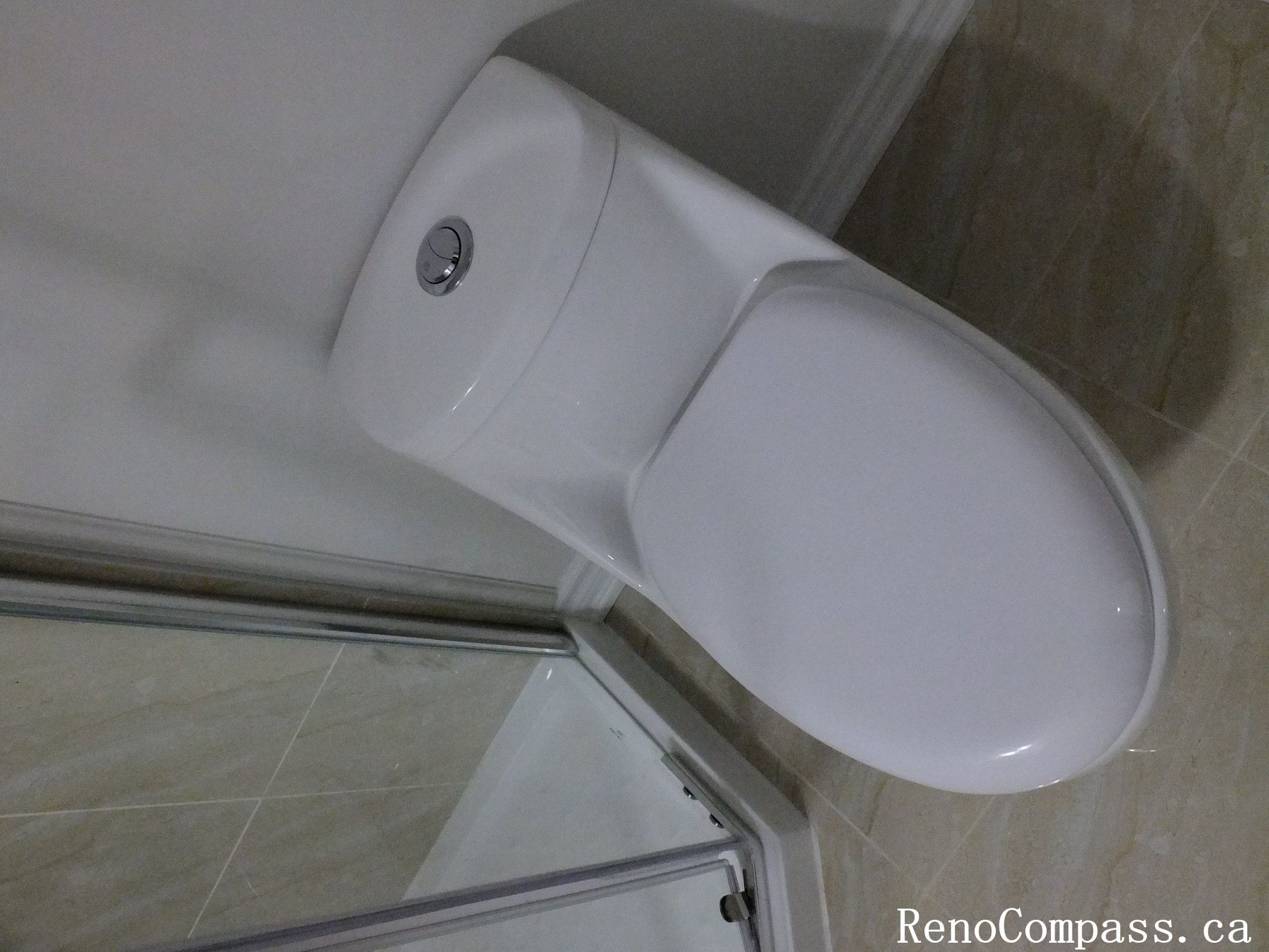 Efficient and stylish toilet installation as part of a Richmond Hill basement bathroom remodel, emphasizing clean lines and bright finishes by Reno Compass