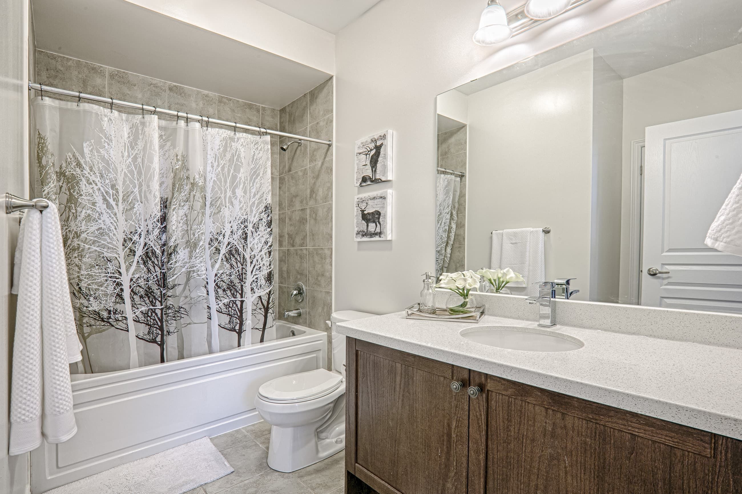 This Toronto modern bathroom renovation features a clean and elegant design with a custom vanity, stone countertop, and full bathtub shower combination. The space is enhanced by modern lighting, large mirror installation, and neutral tile finishes that create a bright and comfortable atmosphere. Completed by a professional Toronto renovation company, this bathroom project highlights functional layout planning, quality craftsmanship, and contemporary residential design tailored for modern living.