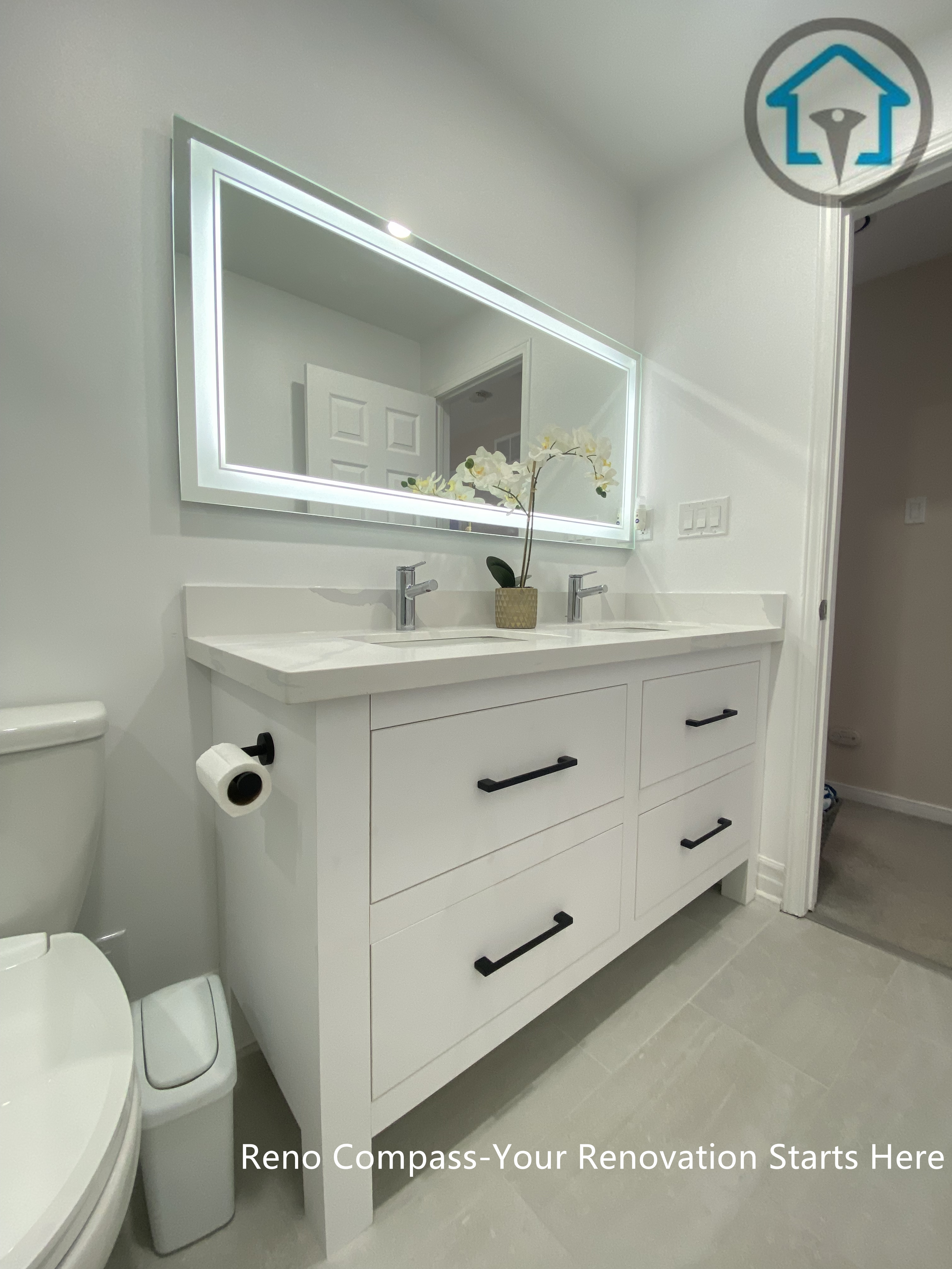 This Pickering bathroom renovation features a custom double vanity designed for both storage efficiency and everyday comfort. Clean-lined white cabinetry is paired with matte black handles for subtle contrast, while the integrated LED mirror provides even lighting and visual depth. The layout keeps the space organized and functional without compromising on a clean, modern aesthetic.