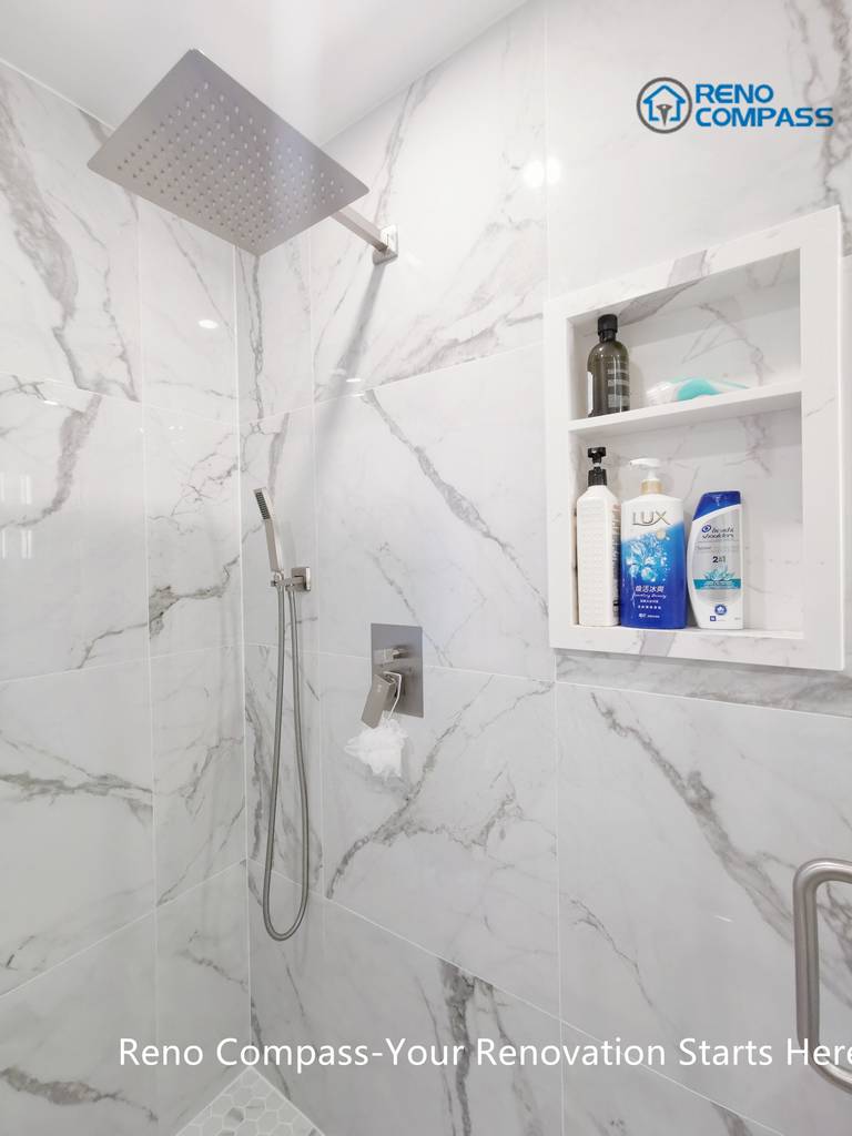 This Mississauga bathroom renovation highlights a frameless walk-in shower finished with large-format marble-look porcelain tiles. A ceiling-mounted rain shower head, handheld fixture, and built-in wall niche improve everyday comfort while maintaining a clean, minimalist appearance. The recessed storage niche enhances functionality without interrupting the visual flow of the space. Precision tile installation and thoughtful detailing reflect the quality standards expected from a professional Toronto renovation company.
