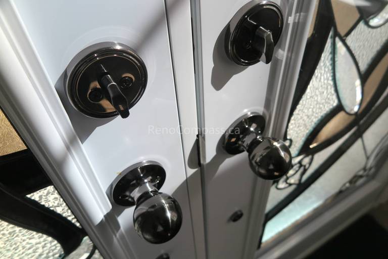 Close-up detail of newly installed double entry door hardware in a Newmarket home, featuring modern black handles and secure locking systems paired with decorative privacy glass panels. Completed by a professional Toronto Renovation Company, this door upgrade enhances both security and visual appeal while adding a refined, high-end finish to the home’s main entrance.