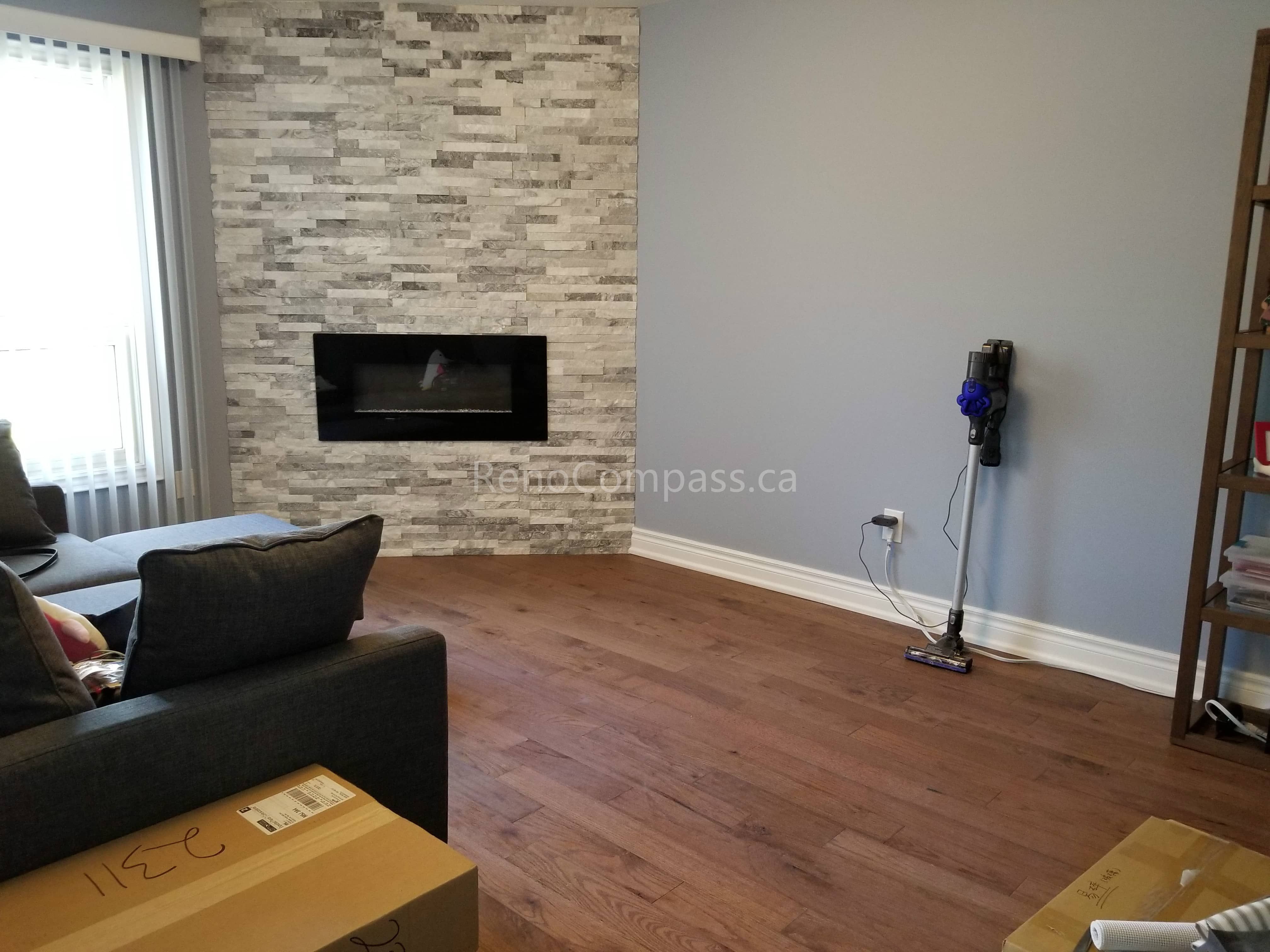 This Mississauga interior renovation showcases a modern living room upgrade featuring a custom stacked stone fireplace wall and warm-toned hardwood flooring. The sleek built-in electric fireplace creates a stylish focal point, while the open layout and neutral wall colors enhance natural light and spaciousness.

Completed by Reno Compass Inc., this renovation combines contemporary design, quality materials, and professional craftsmanship to deliver a comfortable and elegant living environment for the homeowner.