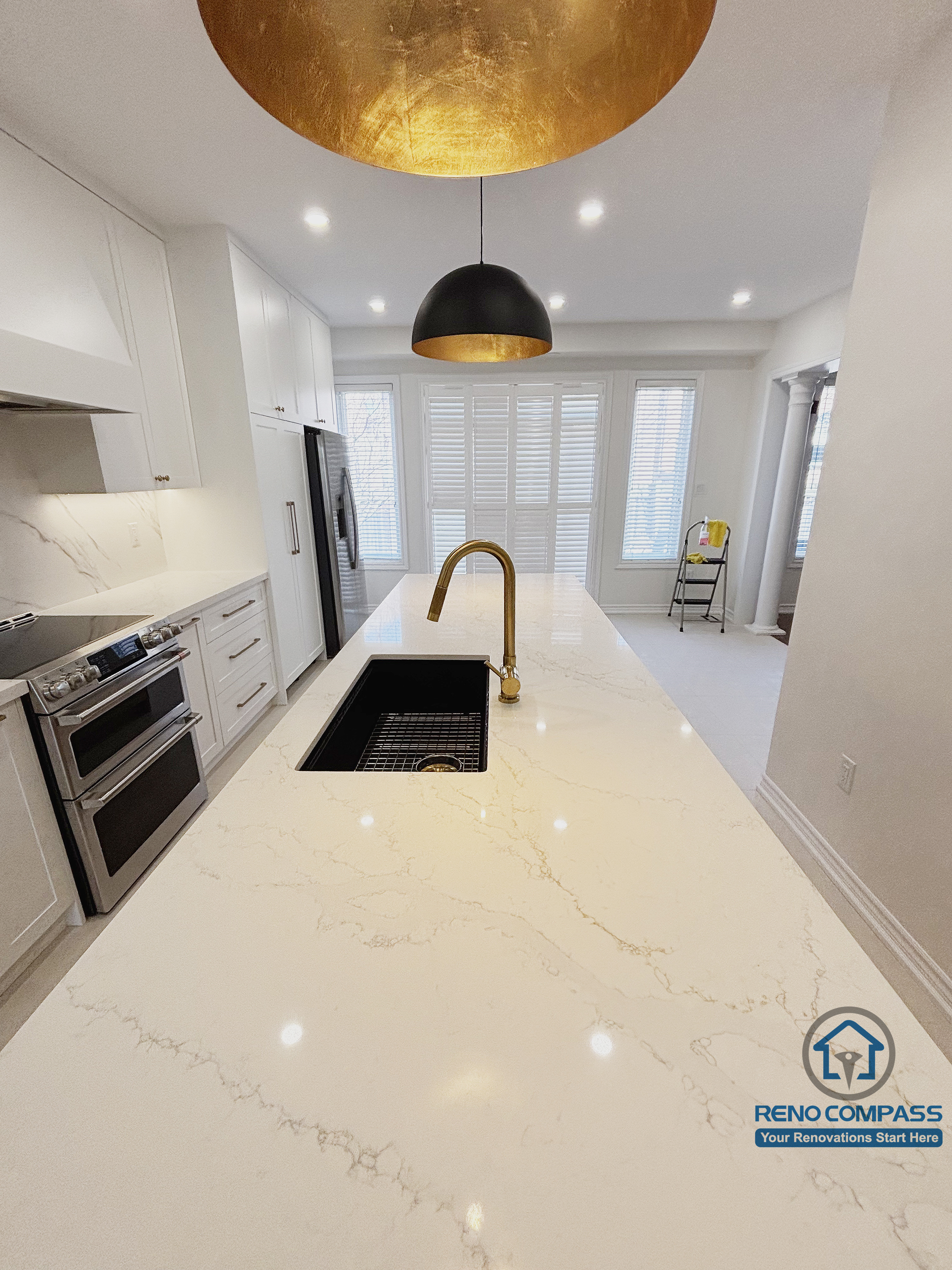 This Oakville kitchen renovation focuses on the island work surface, featuring a quartz countertop with subtle veining, an integrated sink, and streamlined fixtures designed for daily cooking tasks. The elongated island enhances workflow efficiency while maintaining visual clarity across the kitchen and adjacent living area. Soft pendant lighting and clean material transitions contribute to a calm, functional environment. Completed by Reno Compass, this design emphasizes practicality, durability, and everyday usability in a modern Oakville home.