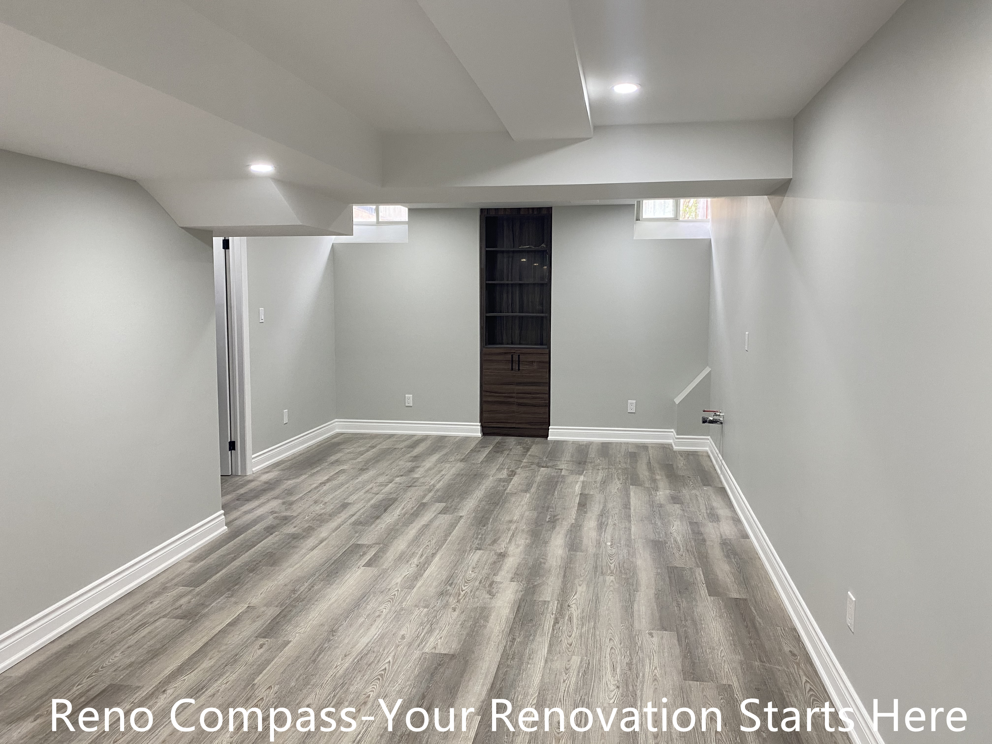 This finished basement in Aurora features a versatile open space designed for multiple uses, including a family lounge, home gym, or media room. The renovation focuses on maximizing headroom through clean ceiling transitions, combined with recessed lighting to evenly brighten the space. Neutral wall colors and durable wood-look flooring create a calm, modern atmosphere while maintaining practicality for everyday use. Thoughtful layout planning ensures smooth circulation and future flexibility. Completed by Reno Compass, a Toronto renovation contractor specializing in basement renovations.