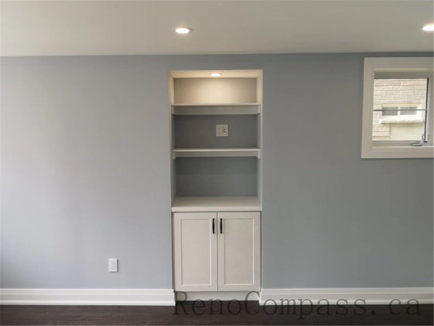 A clean, minimalist basement bathroom renovation showcasing smooth surfaces, recessed lighting, and neutral colors. Reno Compass transformed this Aurora space into a bright, practical area.
