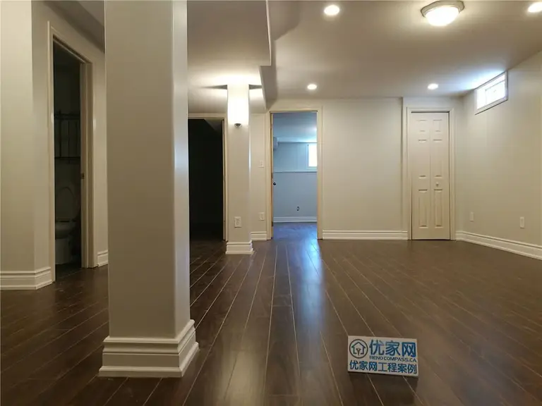 A beautifully renovated basement in Richmond Hill featuring dark hardwood floors, soft neutral paint tones, recessed ceiling lighting, and clean modern trim work. This fully finished space is part of a complete interior renovation by Reno Compass.