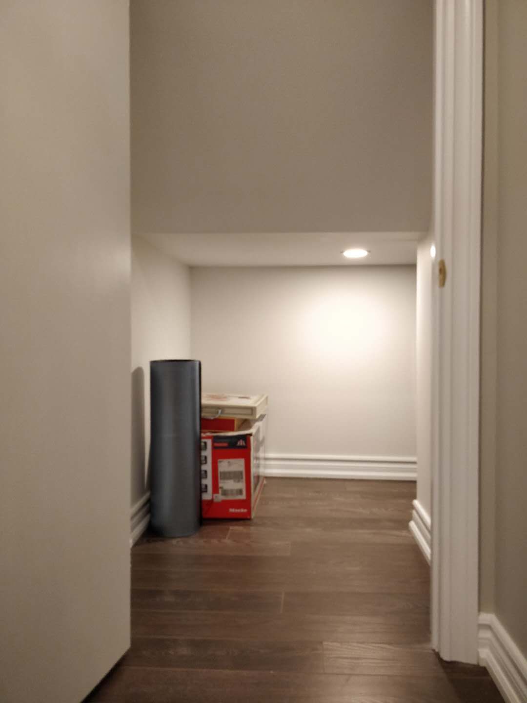 This Scarborough basement renovation features a newly finished hallway with modern hardwood flooring, clean painted walls, and recessed pot lighting. The upgraded basement layout improves accessibility and creates a bright transition space connecting different rooms, completed by a professional Toronto renovation company.