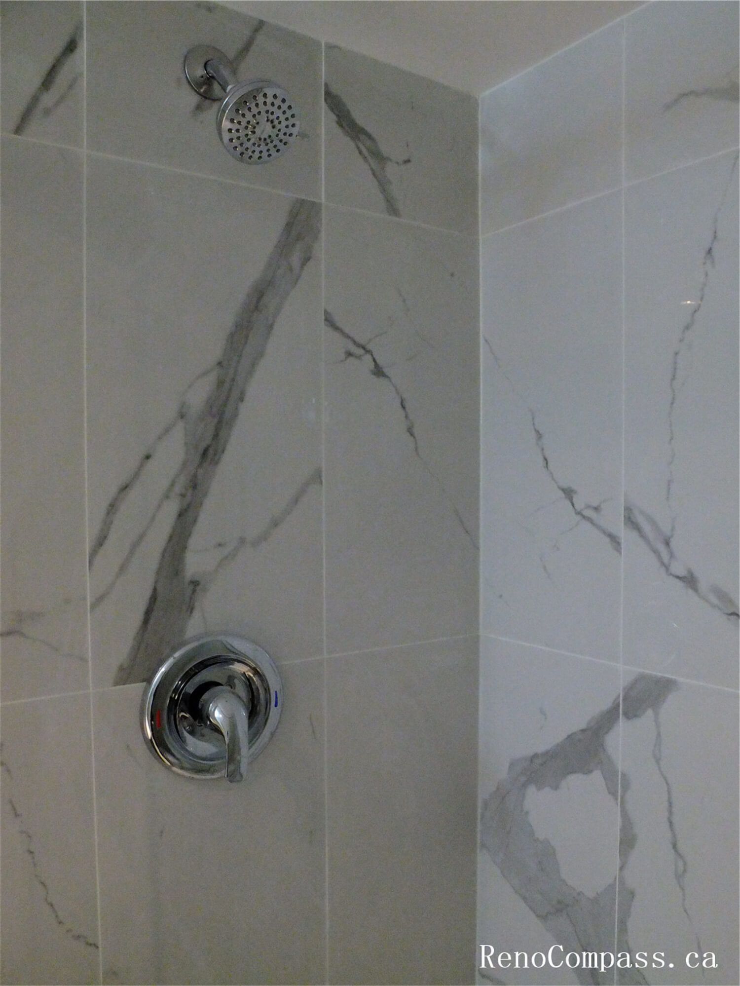 Close-up view of marble-style wall tiles installed in the shower area during this Ajax basement renovation. The large-format tiles with natural grey veining create a clean and elegant bathroom design while providing a durable, moisture-resistant surface ideal for shower spaces. Completed by a professional Toronto Renovation Company, this tile installation enhances both the modern aesthetic and long-term functionality of the basement bathroom.