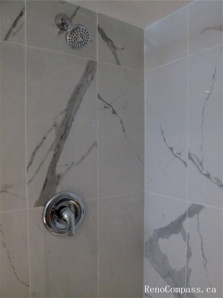 Close-up view of marble-style wall tiles installed in the shower area during this Ajax basement renovation. The large-format tiles with natural grey veining create a clean and elegant bathroom design while providing a durable, moisture-resistant surface ideal for shower spaces. Completed by a professional Toronto Renovation Company, this tile installation enhances both the modern aesthetic and long-term functionality of the basement bathroom.
