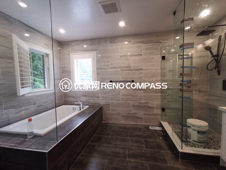 Luxury bathroom interior renovation in Richmond Hill featuring a frameless glass walk-in shower, built-in soaking tub, large-format wall tiles, and modern fixtures. The upgraded layout improves functionality, lighting, and comfort, showcasing high-quality craftsmanship by a professional Toronto renovation company.